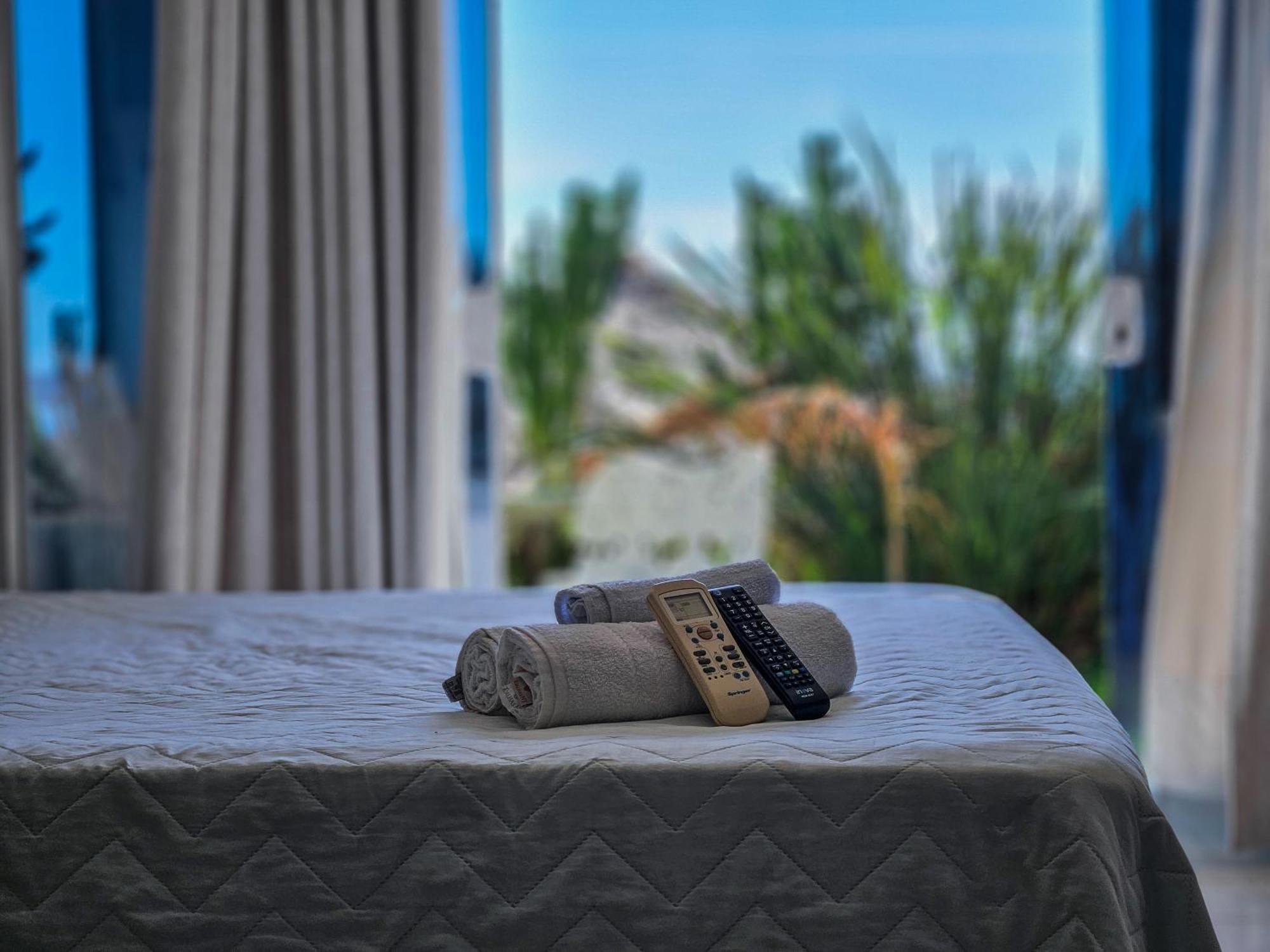 Bella Vista Ocean View Hotel Armacao dos Buzios ภายนอก รูปภาพ A bed with a remote control and a towel